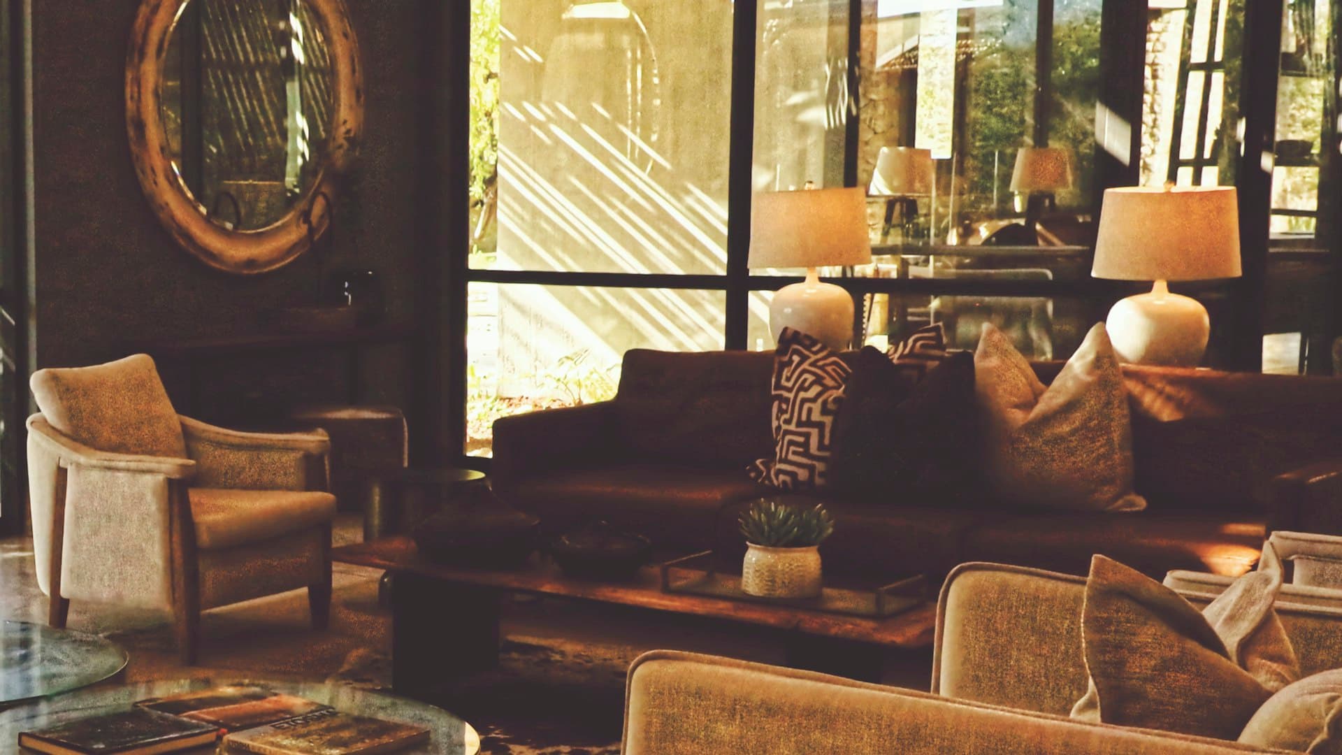 Lounge modern yang nyaman dengan sofa, kursi berlengan, dan lampu bercahaya hangat