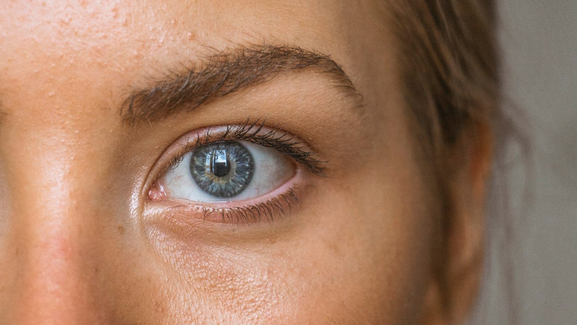 Foto close-up mata dan alis seseorang, memperlihatkan helai alis yang tertata natural