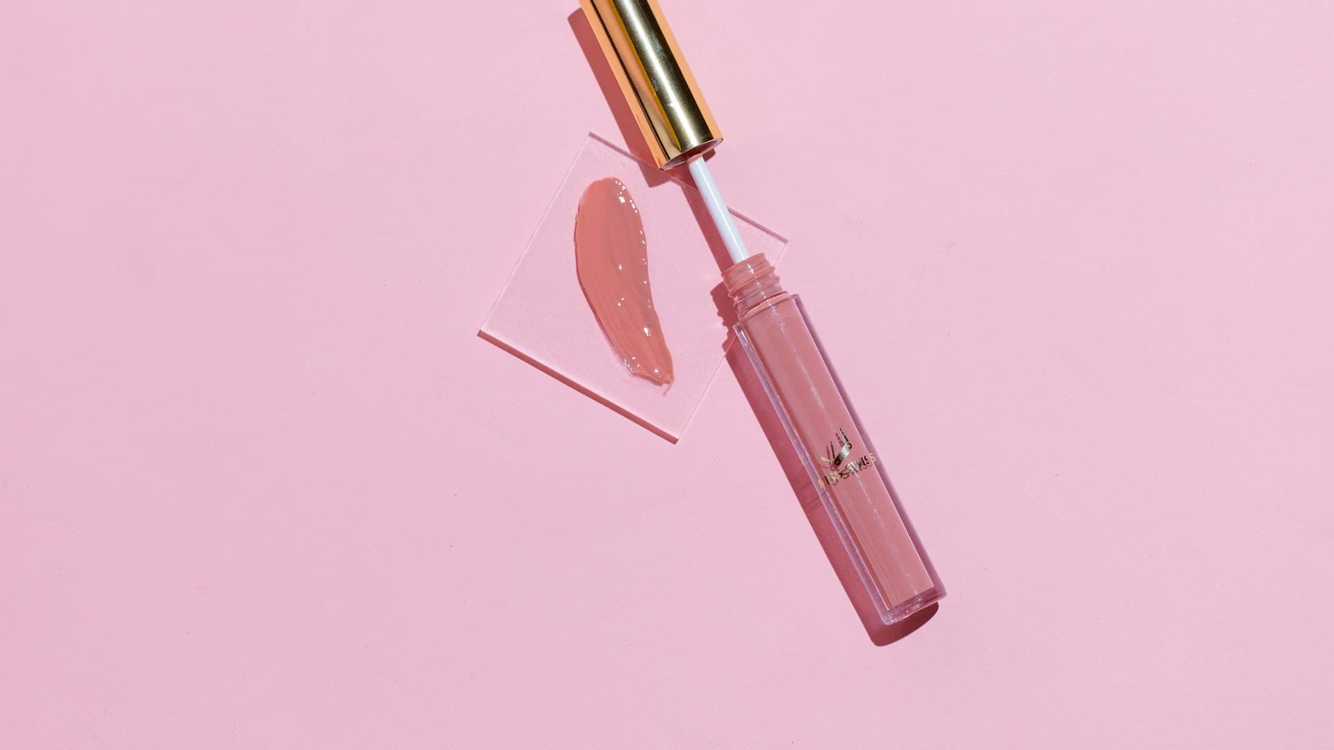 Produk bibir merah muda di atas permukaan senada, kilau glossy yang menjadi pusat pengujian kami
