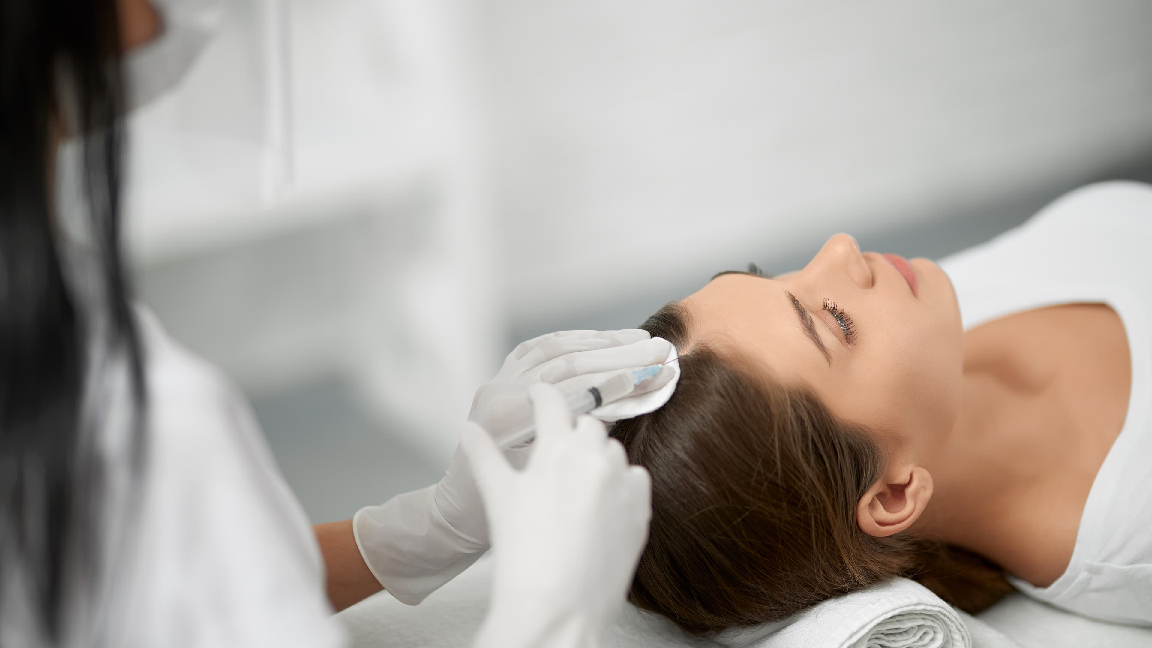 Woman receiving hair regeneration treatment at a clinic