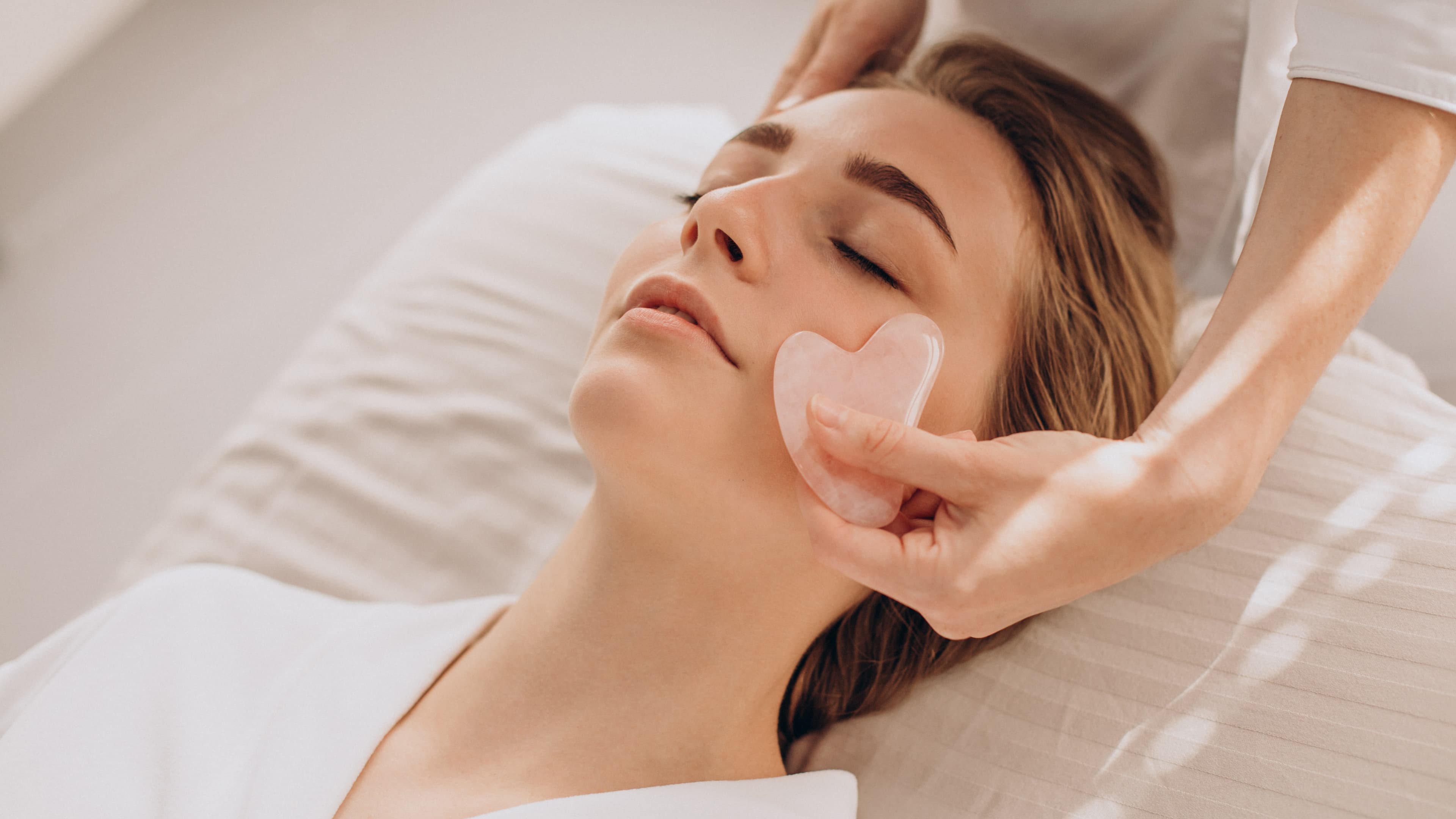 Lymphatic drainage facial massage being performed on a woman's face