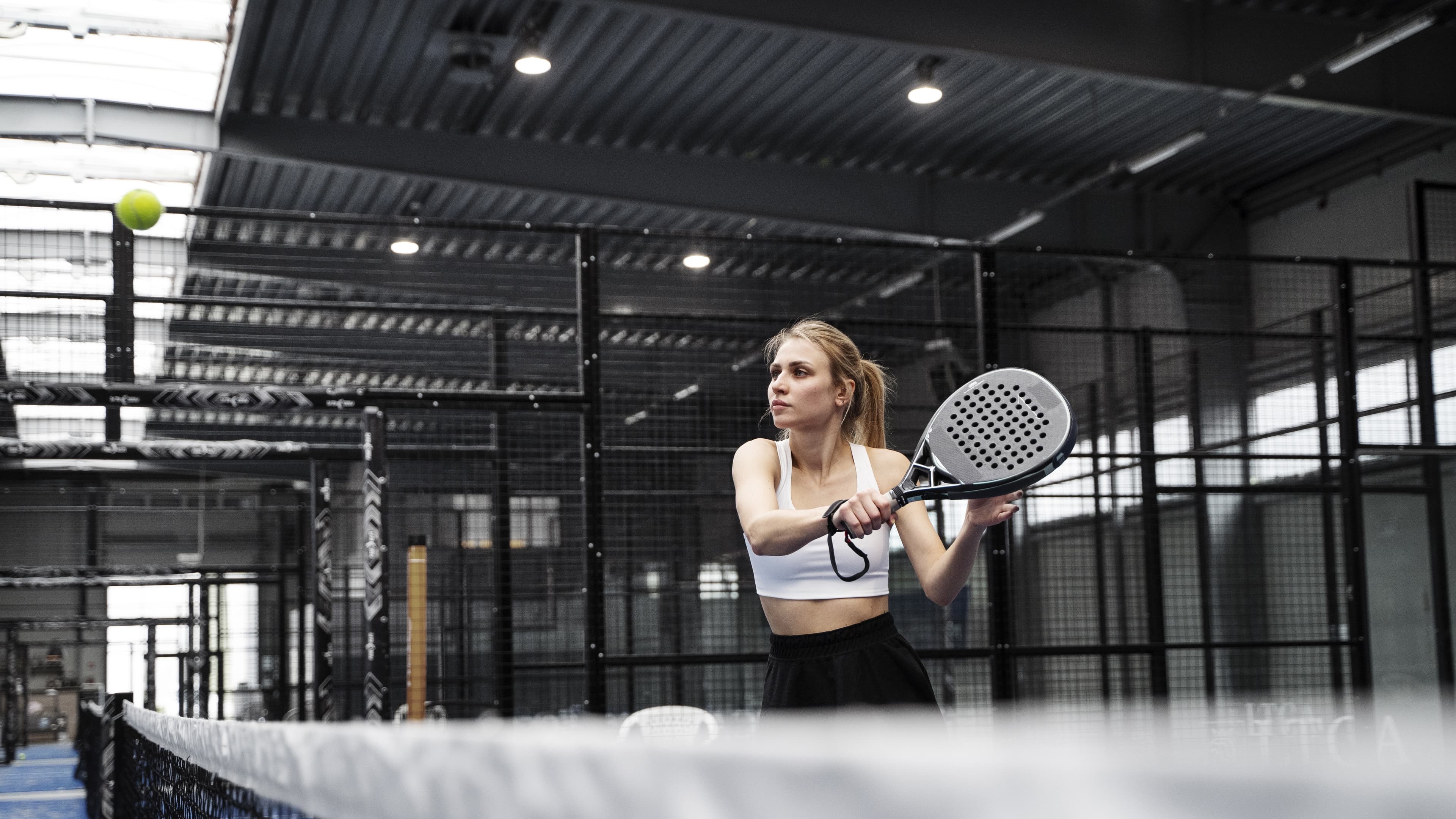 Woman playing padel on a modern court