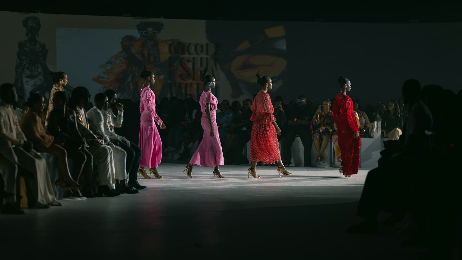 Sekelompok model perempuan berjalan di atas runway dengan tata rias yang seragam dan dramatis