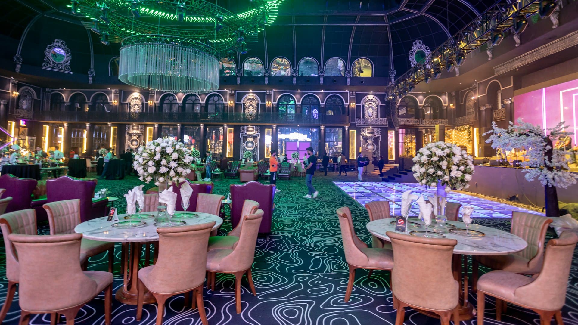 Ruang acara hotel mewah yang temaram di malam hari dengan cahaya keemasan