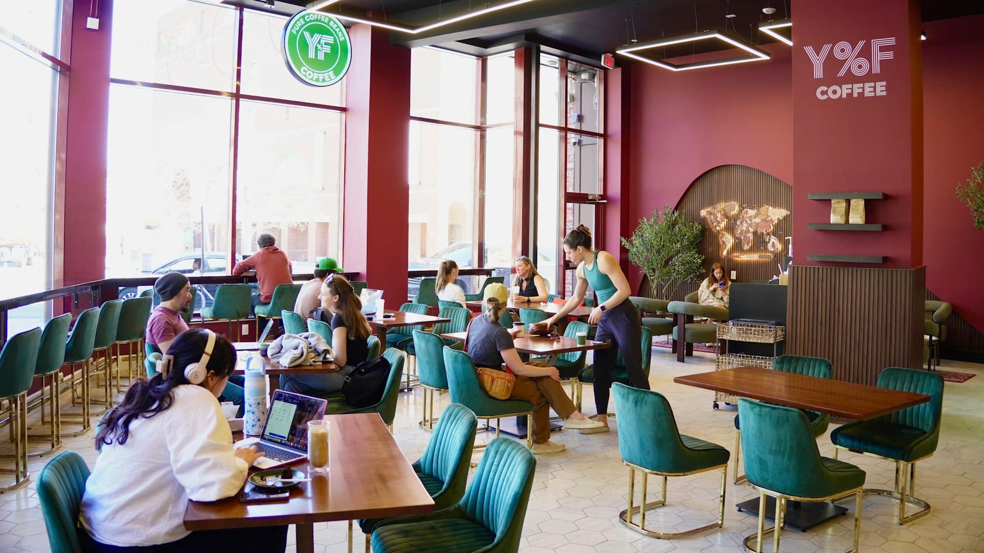 Suasana kedai kopi modern dengan orang-orang bekerja dan bersosialisasi, kehangatan yang terjaga setiap hari