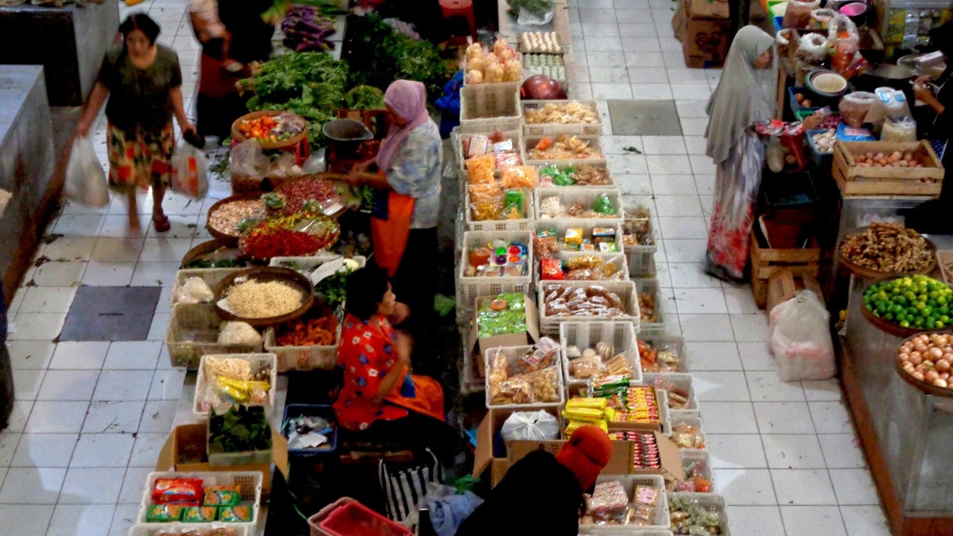 Suasana pasar tradisional tempat perempuan berbelanja rempah dan bahan segar untuk jamu