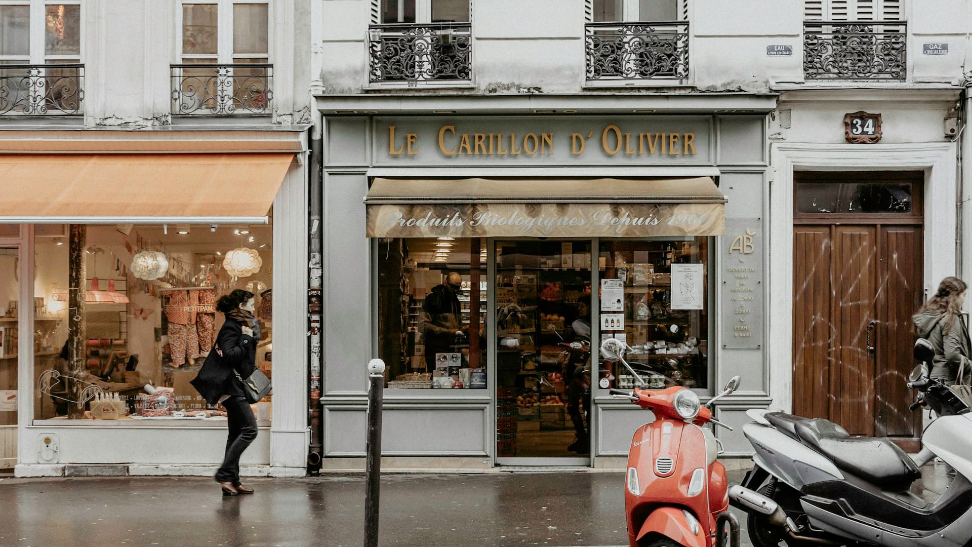 Skuter merah-hitam terparkir di depan butik klasik di sudut jalan Paris