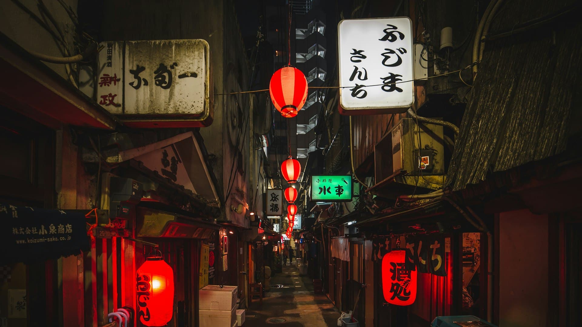 Jalanan kecil Tokyo di malam hari dengan cahaya lampu toko yang temaram